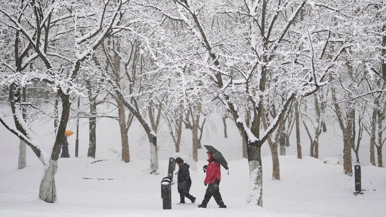 People walk through the snow in Goyang, South Korea, Saturday, Dec. 30, 2023. South Korean Meteorological Administration issued a heavy snow advisory for some parts of the Korea peninsula. (AP Photo/Lee Jin-man)