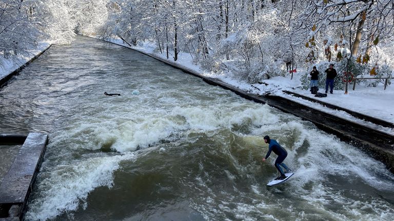 A man surfs the waves on the Eisbach river, one day after heavy snowfall hit Bavaria and its capital Munich, Germany, December 3, 2023. REUTERS/Louisa Off