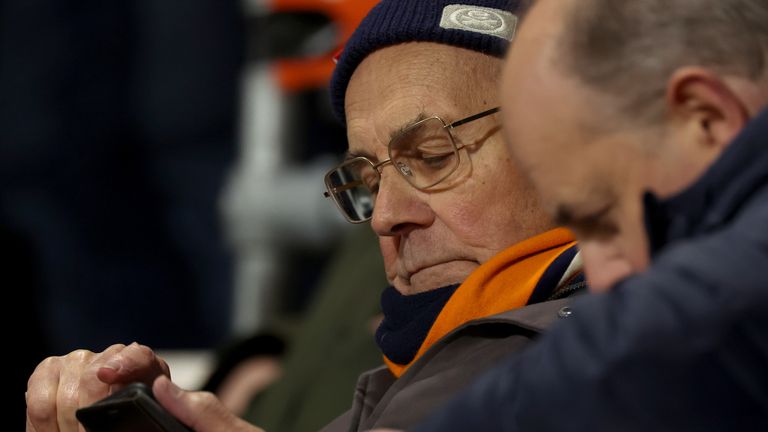 A Luton Town fan checks his phone after Tom Lockyer was taken from the field by medical staff after appearing to collapse on the field during the Premier League match at the Vitality Stadium, Bournemouth. Picture date: Saturday December 16, 2023.