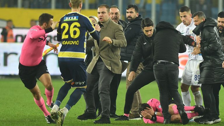  Referee Halil Umut Meler lies on the ground during the melee