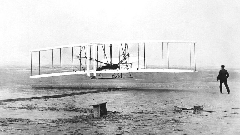 Orville Wright is at the controls of the "Wright Flyer" as his brother Wilbur Wright looks on during the plane&#39;s first flight at Kitty Hawk, N.C. Dec. 17, 1903. Made of wood, wire and cloth by two bicycle mechanics, the plane remained aloft for 12 seconds and travelled a distance of 120 feet. (AP Photo/Virginian-Pilot, John T. Daniels)