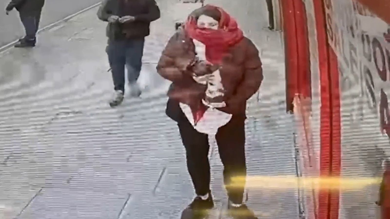 Изображение Констанс Мартен държаща бебе Виктория под палтото си в