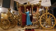 A gallery assistant stands on the steps of the world&#39;s only reproduction of the Gold State Coach, which is part of the collection of more than 450 costumes, sets and props from the Netflix series The Crown, on show at Bonhams in central London, ahead of being auctioned next month. Picture date: Tuesday January 9, 2024.


