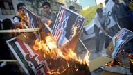 Iranians burn placards of U.S. and Israeli flags in front of the former U.S. embassy compound in Tehran November 4, 2002. Exactly 23 years after the U.S. embassy takeover in Tehran, a hardline Iranian court jailed Abbas Abdi, one of the former hostage takers who is now a leading voice for reform in the Islamic Republic. REUTERS/Morteza Nikoubazl CJF/WS
