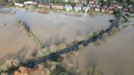 Cars drive along flooded land after the River Arun burst its banks in the aftermath of Storm Henk, at Pulborough
