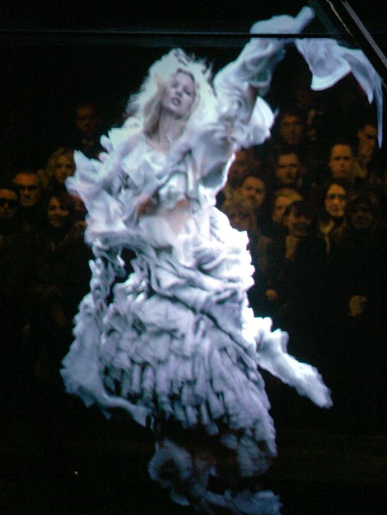 A holographic image of Kate Moss floats in yards of rippling fabric at the presentation of the Alexander McQueen Fall/Winter 2006/2007 ready-to-wear collection in Paris March 3, 2006. British designer McQueen had an image of the supermodel emerge out of smoke in a holographic installation at his ready-to-wear show on Friday, paying tribute to Moss, who lost advertising contracts after a cocaine scandal last year. Picture taken March 3, 2006. REUTERS/Charles Platiau

