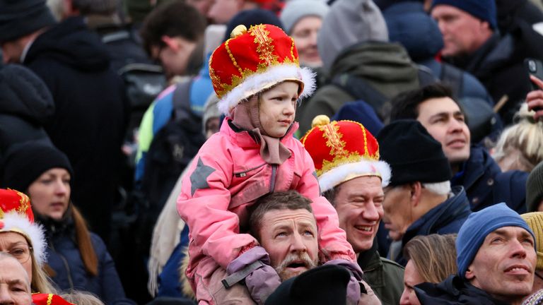 A child, wearing a crown, looks on as people gather, on the day Danish Queen Margrethe abdicates after 52 years on the throne