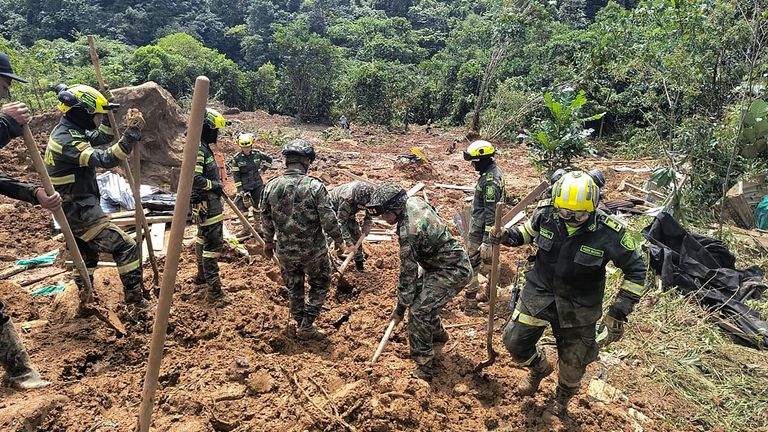 Rescuers search for survivors of a landslide caused by heavy rains in Choco