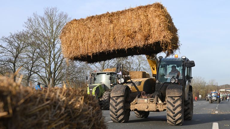 Farmers install hay bales on a highway near Paris&#39;s main airport near Roissy-en-France, north of Paris. 
Pic: AP