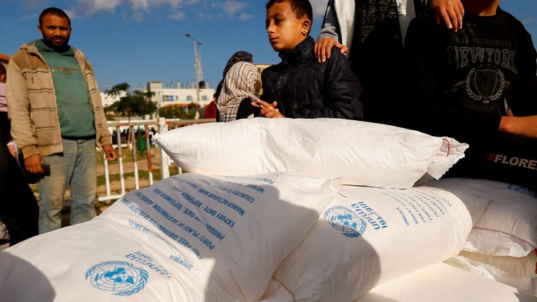 Palestinians receive flour bags distributed by UNRWA in Rafah, in the southern Gaza Strip