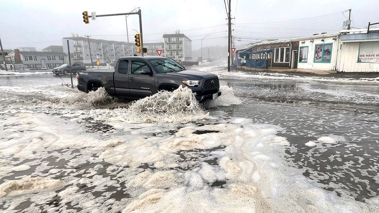 The Atlantic Ocean spills over the seawall and flows into an intersection on Ocean Blvd. in Hampton, N.H., Wednesday morning Jan. 10, 2024. . (Deb Cram/Foster&#39;s Daily Democrat via AP)