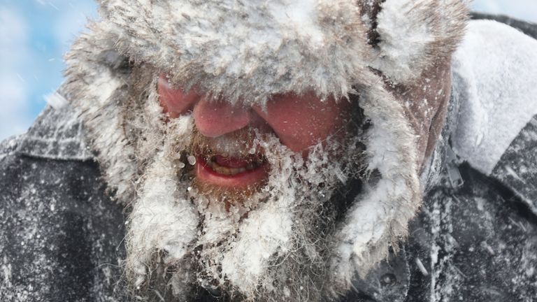 Icy conditions affected a worker&#39;s beard as he tried to clear snow from the stadium. Pic: AP