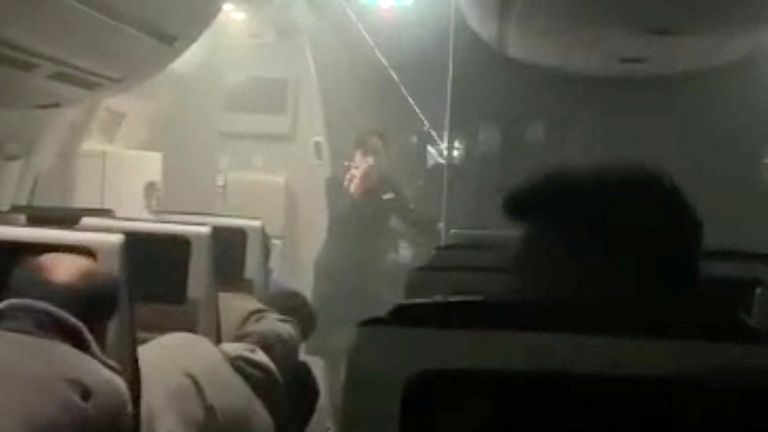 People sit amid smoke inside the Japan Airlines&#39; A350 airplane in this screen grab obtained from social media video. Video Obtained by Reuters/via REUTERS  THIS IMAGE HAS BEEN SUPPLIED BY A THIRD PARTY.