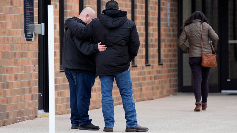 People embrace outside the McCreary Community Building where families are being reunited following a shooting at Perry High School, Thursday, Jan. 4, 2024, in Perry, Iowa. (AP Photo/Charlie Neibergall)