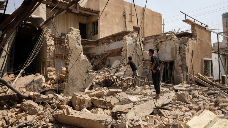 People look at the destroyed office of the Asaib Ahl al-Haq paramilitary group after an attack during clashes between rival Shiite militants in Basra, Iraq, September 1, 2022. REUTERS/Issam Al-Sudani