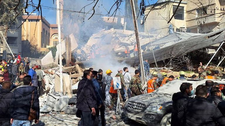 People inspect a damaged site in Damascus