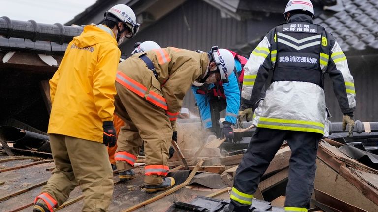 Firefighters and rescue workers search a collapsed house caused by powerful earthquake in Suzu, Ishikawa Prefecture Wednesday, Jan. 3, 2024. A series of powerful earthquakes hit western Japan, damaging buildings, vehicles and boats, with officials warning people in some areas on Tuesday to stay away from their homes because of a risk of more strong quakes. (AP Photo/Hiro Komae)