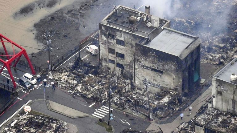 White smoke is seen from a burnt building hit by earthquakes in Wajima, Ishikawa prefecture, Japan Wednesday, Jan. 3, 2024. A series of powerful earthquakes that hit western Japan left multiple people dead and damaged thousands of buildings, vehicles and boats. Officials warned Tuesday that more quakes could lie ahead.  (Kyodo News via AP)
