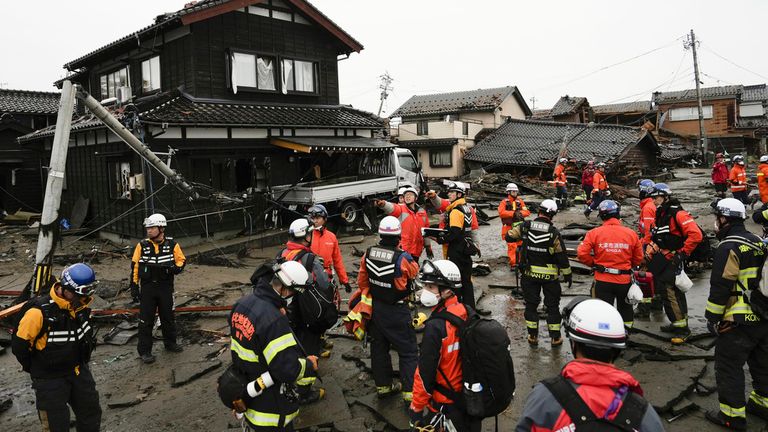 Firefighters and police search coastal area hit by earthquakes in Suzu, Ishikawa prefecture, Japan Wednesday, Jan. 3, 2024. Rescue workers and canine units urgently sifted through rubble Wednesday ahead of predicted freezing cold and heavy rain in what the prime minister called a race against time after powerful earthquakes in western Japan killed multiple people. Dozens are believed trapped under collapsed buildings.(Kyodo News via AP)