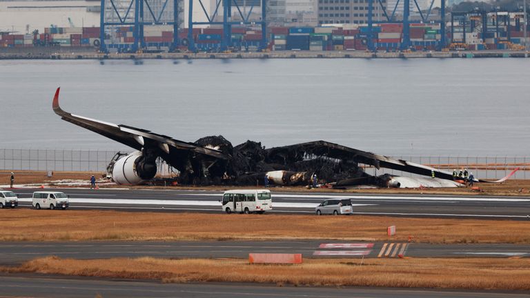 Officials investigate a burnt Japan Airlines (JAL) Airbus A350 plane after a collision with a Japan Coast Guard aircraft at Haneda International Airport in Tokyo, Japan January 3, 2024. REUTERS/Issei Kato/File Photo