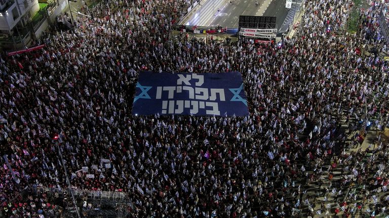 People take part in a demonstration against Israeli Prime Minister Benjamin Netanyahu and his nationalist coalition government&#39;s judicial overhaul, in Tel Aviv, Israel, September 30, 2023. The banner reads "Don?t separate us". REUTERS/Ilan Rosenberg