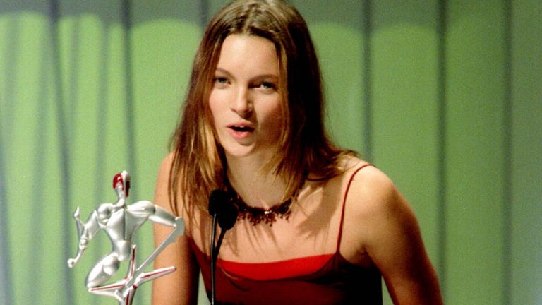 British super model Kate Moss speaks from the podium during the 1996 VH-1 fashion awards in New York City October 24. Moss received an award (front) for Female Model of the Year award.

