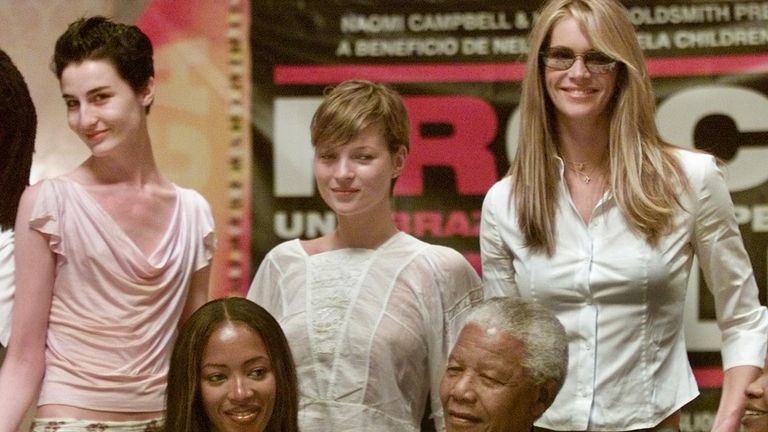 Model Naomi Campbell, former South African president Nelson Mandela, and behind (L-R) models Erin O'Connor, Kate Moss and Elle Macpherson pictured ahead of a media conference in Barcelona June 30, 2001