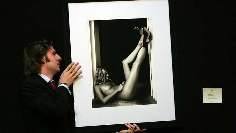 A man hangs a portrait of Kate Moss by artist Sam Taylor Wood at Christie's auction house in London in May 2005. President and founder of Jimmy Choo shoes, Tamara Mellon, unveiled a series of nude portraits of women including Kate Moss and Victoria Beckham wearing nothing but Jimmy Choo shoes and Cartier jewellery, to raise money for the Elton John Aids Foundation