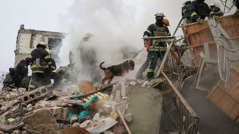 Rescuers at the site of a damaged building in Kharkiv