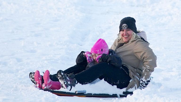 A woman and child on a sledge at Camp Hill in Woolton, Liverpool