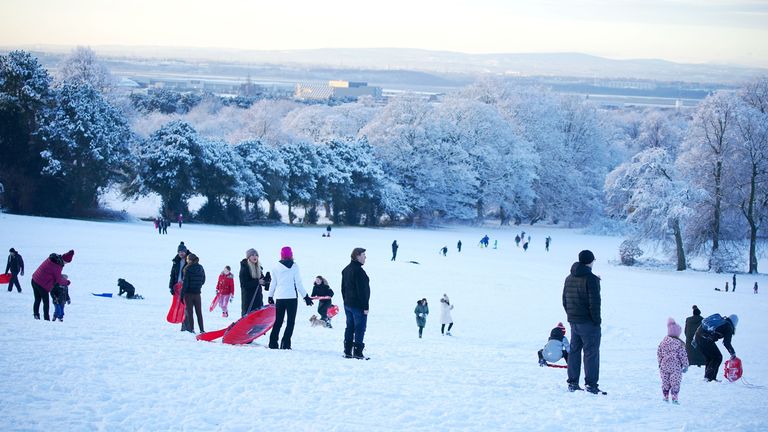 People take advantage of the snowy weather with sledges at Camp Hill in Woolton, Liverpool