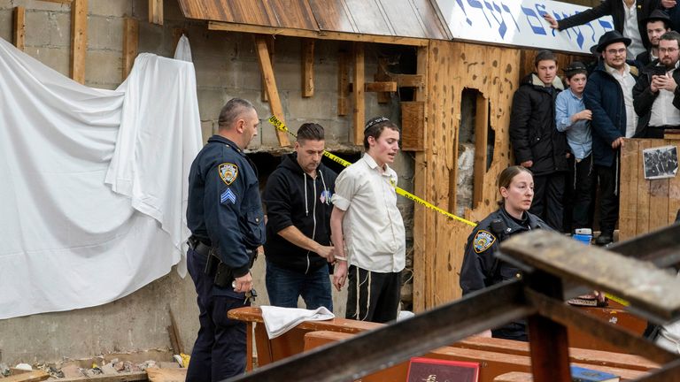 New York Police officers arrest a Hasidic Jewish student after he was removed from a breach in the wall of the synagogue that led to a tunnel dug by students
Pic:AP