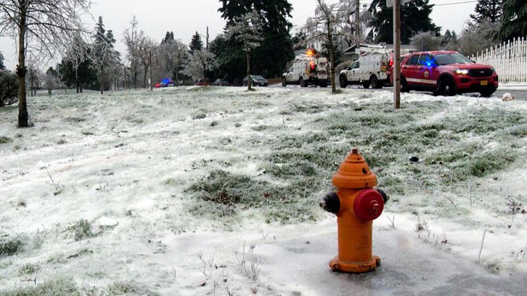 In this image made from a video provided by KGW, authorities work the scene Wednesday, Jan. 17, 2024, in Portland, Ore, after a power line fell on a vehicle, killing three people and injuring a baby during an ice storm that turned roads and mountain highways treacherous in the Pacific Northwest. (KGW via AP)