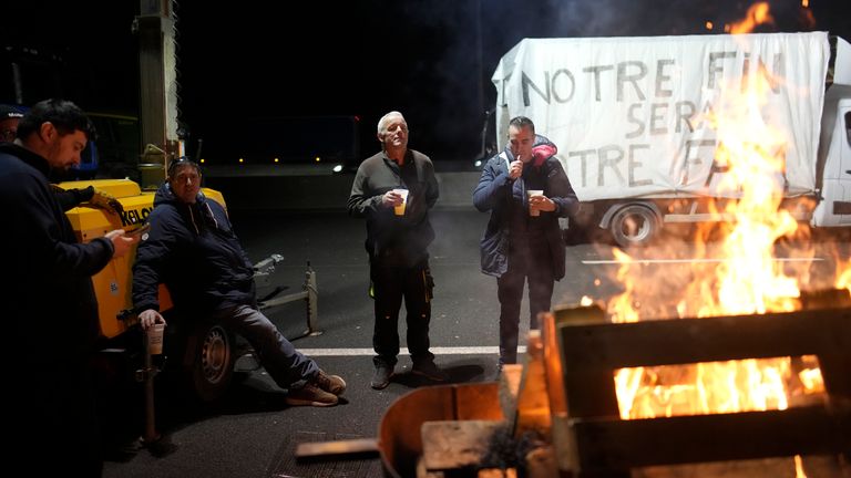 Farmers gather at a barbecue as they block a highway in Argenteuil, north of Paris.  
Pic:AP