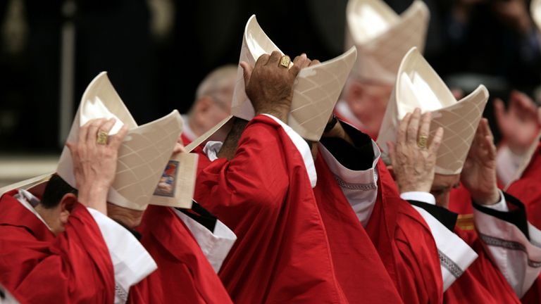 Kardynałowie trzymają czapki podczas mszy przewodanej przez (niemiecki kardynał Joseph Ratzinger) w bazylice św. Piotra w Watykanie 18 kwietnia 2005 r. Kardynałowie spotkają się później w kaplicy Sistine na początek papieży.
