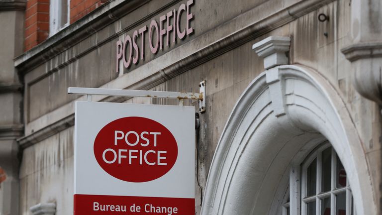A post office sign hangs above a shop