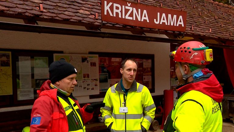 In this photo taken from video, rescuers gather outside the Krizna Jama cave near Grahovo, Slovenia, Sunday, Jan. 7, 2024. Slovenian authorities say five people are trapped in a cave in the southwest of the country because of high water levels caused by heavy rainfall. The group includes a family of three and two guides who have been stuck in the Krizna Jama cave since Saturday when water levels rose inside, blocking the way out. (Pop TV via AP)