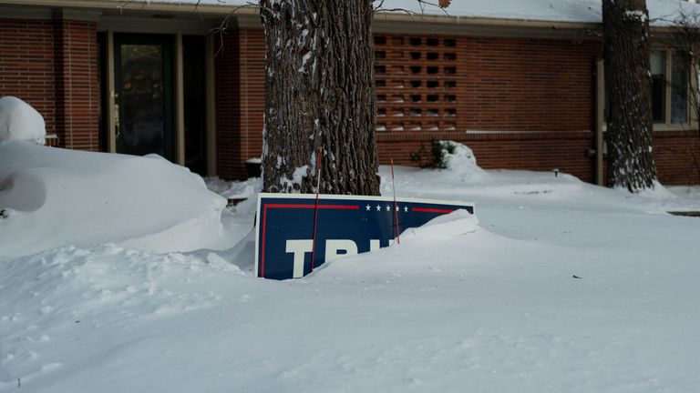 A sign for Donald Trump covered in the snow