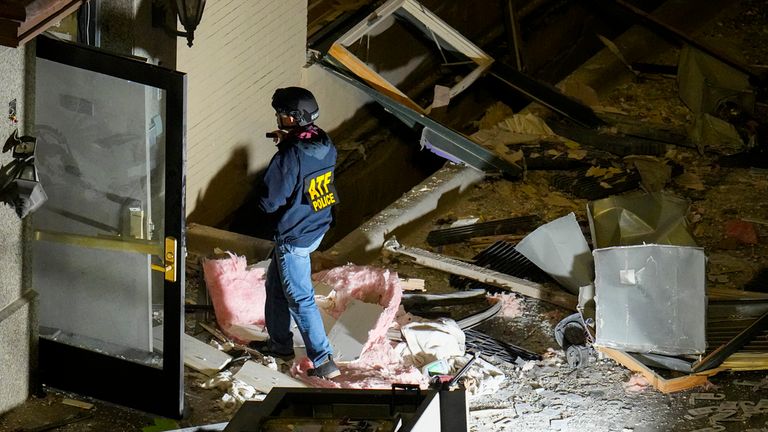 An official surveys an area near the back entrance to the Sandman Signature hotel following an explosion, Monday, Jan. 8, 2024, in Fort Worth, Texas. (AP Photo/Julio Cortez)