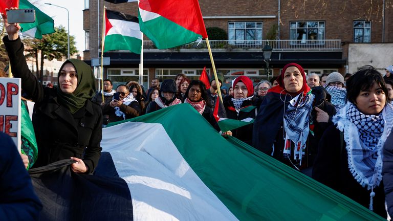 People hold flags during a pro-Palestinian demonstration outside the International Court of Justice today