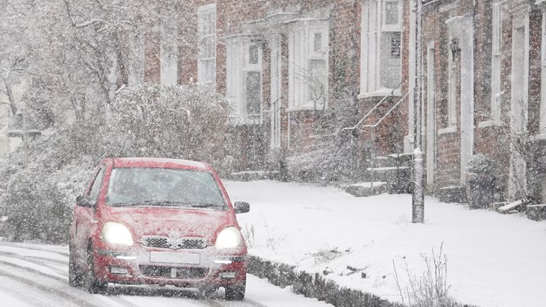 A car drives through a snow flurry in Lenham, Kent, on Monday