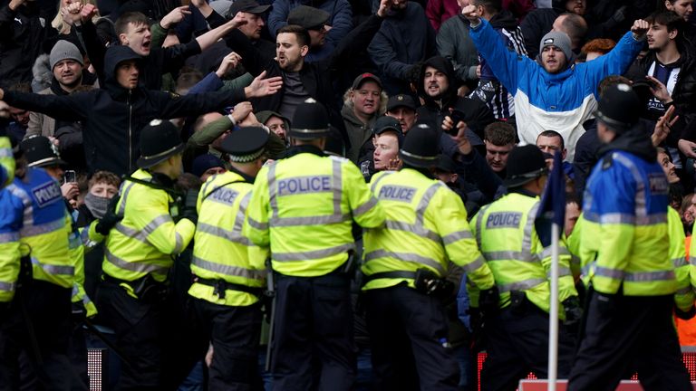 Police officers on the pitch after the match was halted after fans entered the field of play. Pic: PA