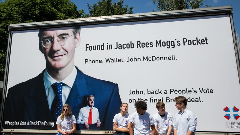 William Dry (2nd right) sit in front of a billboard showing Shadow Chancellor John McDonnell in the pocket of prominent pro-Brexit MP Jacob Rees-Mogg in the former&#39;s constituency of Hayes and Harlington
Pic:Alamy