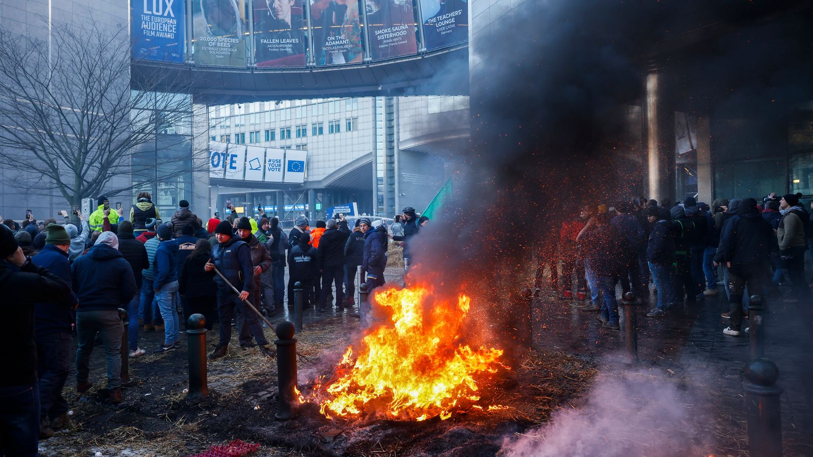 Фойерверки експлодират и гъст дим изпълва въздуха, докато кипящите фермери пристигат пред вратата на Брюксел