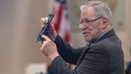 Lucien Haag, forensic science firearms evidence examination and shooting reconstruction expert witness, shows the jury a gun exactly like the evidence gun during the Hanna Gutierrez-Reed trial at District Court, in Santa Fe, New Mexico, U.S., February 27, 2024. Luis Sanchez Saturno/Pool via REUTERS
