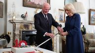 President of The Poppy Factory Surgeon Rear Admiral Lionel Jarvis helps Queen Camilla to slice a cake with a sword during a celebration at Clarence House, central London, marking the centenary of The Poppy Factory, which was founded in the aftermath of the First World War. The reception also marks 100 years since the charity began the move to its historic home in Richmond upon Thames, south west London. Picture date: Thursday February 15, 2024.