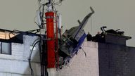 Pic:  Juan David Duque/Reuters
A helicopter hangs from the roof of a building after crashing due to strong winds, according to authorities, in Medellin, Colombia 
