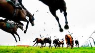 Steeplechase and Horse Racing with horses and jockies running into the distance. Low angle view, high contrast image, bleached look with added grain. Pic: iStock.

