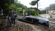 Residents evacuate past damaged vehicles after storms caused a mudslide, Monday, Feb. 5, 2024, in the Beverly Crest area of Los Angeles. A storm of historic proportions unleashed record levels of rain over parts of Los Angeles on Monday, endangering the city&#39;s large homeless population, sending mud and boulders down hillsides dotted with multimillion-dollar homes and knocking out power for more than a million people in California. (AP Photo/Marcio Jose Sanchez)
