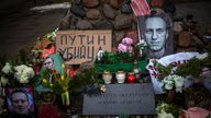 Photos of Alexei Navalny is seen among flowers and candles at the monument to the victims of soviet occupation in Vilnius, Lithuania, Saturday, Feb. 17, 2024. Poster with the words reading "Putin is a killer", left,. Russian authorities say that Alexei Navalny, the fiercest foe of Russian President Vladimir Putin who crusaded against official corruption and staged massive anti-Kremlin protests, died in prison. He was 47. (AP Photo/Mindaugas Kulbis)
